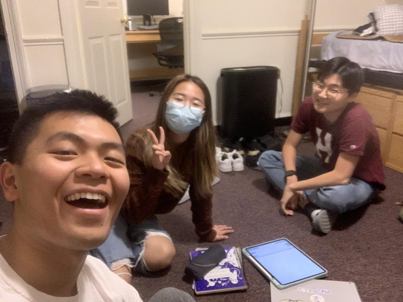 Group picture of the author and his friends working on homework and smiling at the camera.